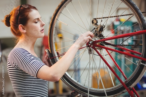 Woman repairing a bicycle wheel photo