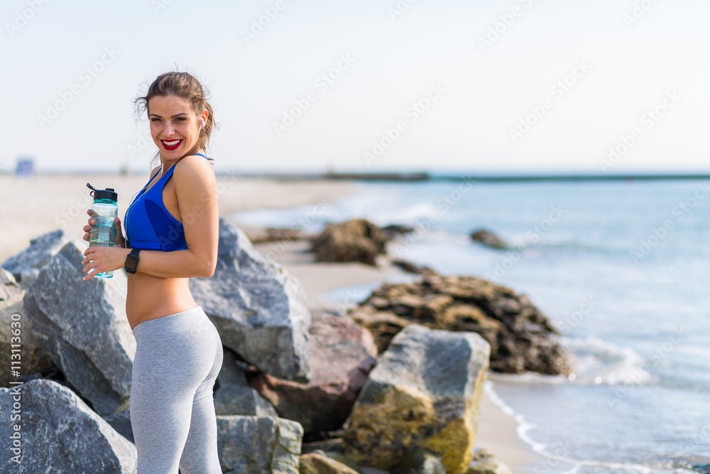 Woman working out outdoors in the summer at the beach