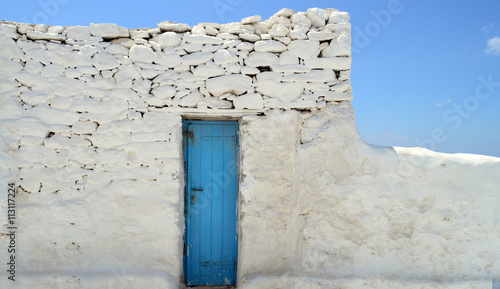 Old painted blue door on the whitewashed wall
