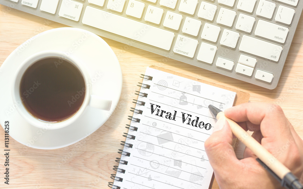 Hand writing on book message Viral Video. A keyboard and a glass coffee table.Vintage tone. Hand writing on book message Viral Video. A keyboard and a glass coffee table.Vintage tone.