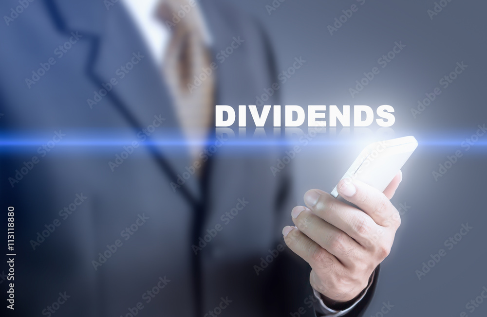 Businessman pressing hand DIVIDENDS message on virtual screen. Can bring to the medium of your ad. Businessman pressing hand DIVIDENDS message on virtual screen. Can bring to the medium of your ad.