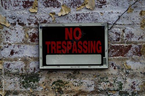 No Trespassing sign on Distressed Brick Wall