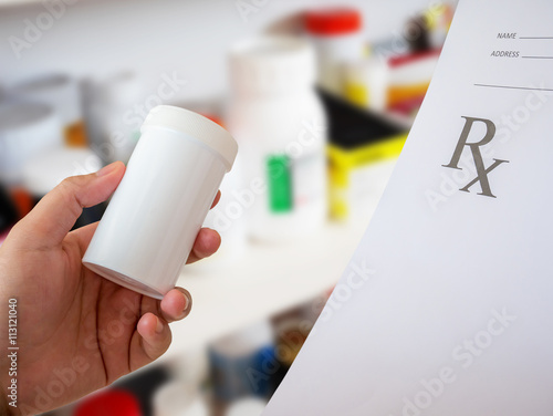 female pharmacist with prescription and medicine bottle at the p