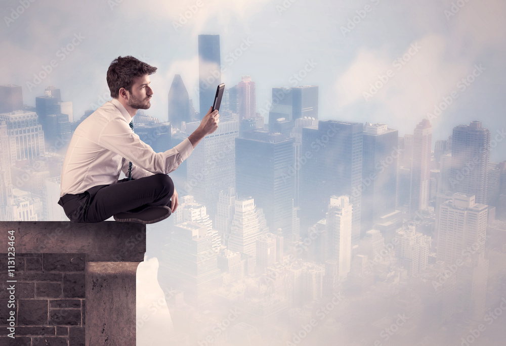 Sales person sitting on top of a tall building Sales person sitting on top of a tall building