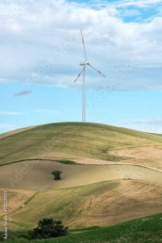 Single wind turbine in farmland on a hilltop
