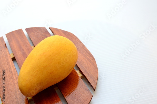 Yellow mango on wooden tray