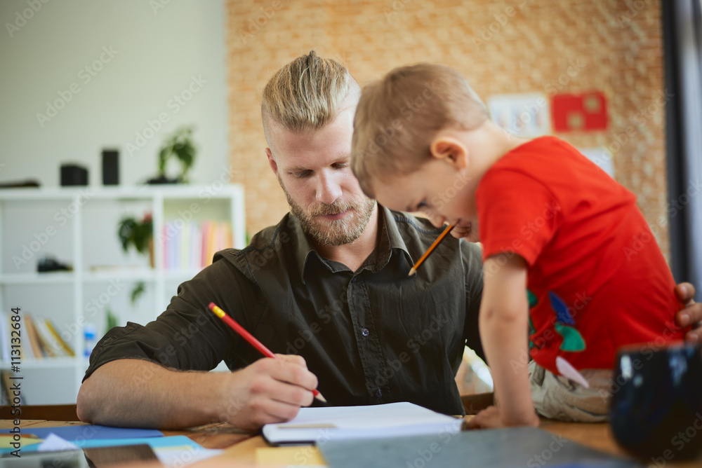 Family business start up concept, man working in home office, son helping him. Family business start up concept, man working in home office, son helping him.