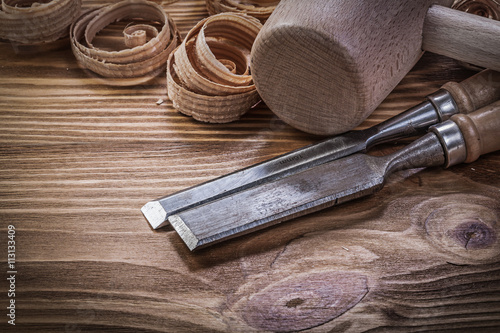 Flat chisels curled shavings wooden hammer on wood board constru photo