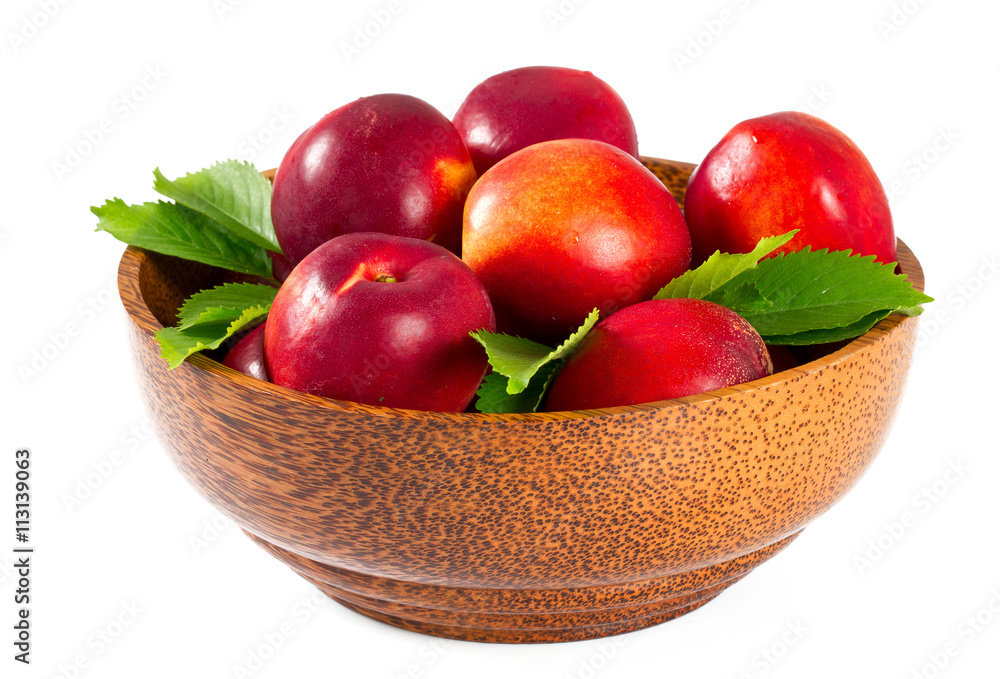 ripe nectarines in a wooden bowl isolated on white ripe nectarines in a wooden bowl isolated on white