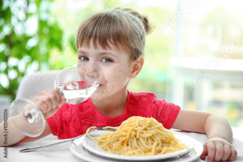 Beautiful small girl eating...