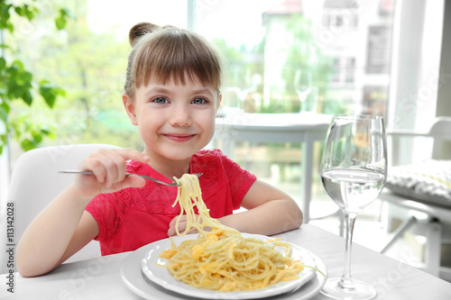 Beautiful small girl eating...