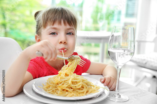 Beautiful small girl eating...