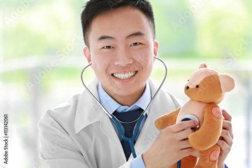 Handsome male doctor holdin...