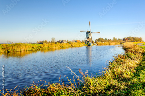 Old Dutch windmill at the bank of a canal
