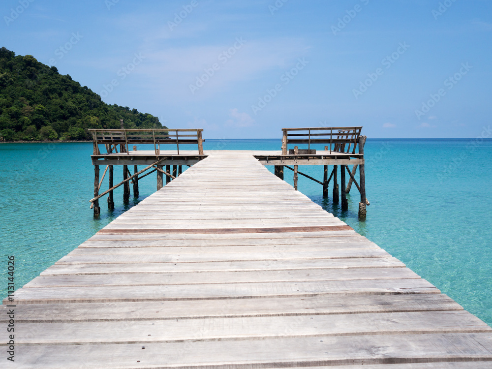 Jetty into blue sea and sky. Pier over water. Vacation And tourism concept. Tropical resort. Jetty on Koh Kood Island, Thailand.