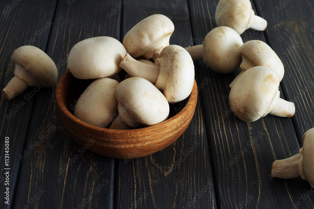 Fresh champignon mushrooms on wooden table Fresh champignon mushrooms on wooden table