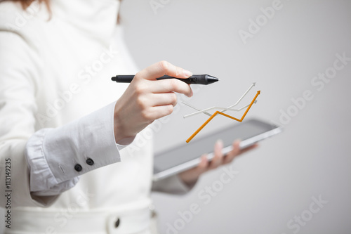 Businesswoman working with growth graph on grey background