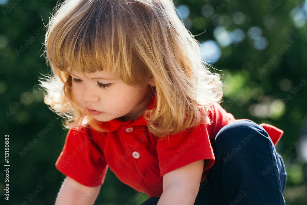 Fototapeta premium Little boy looks down