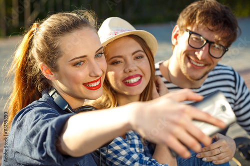 Smiling friends making selfie outdoors
