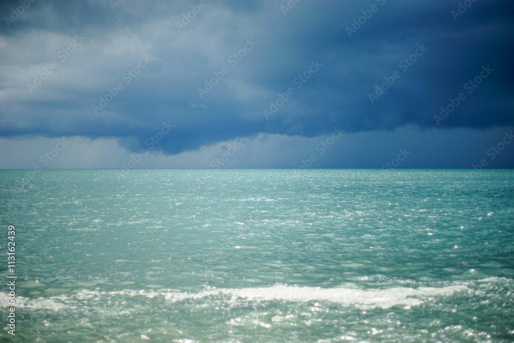 the sea with rainy cloud, and blured out of focus sea wave splash