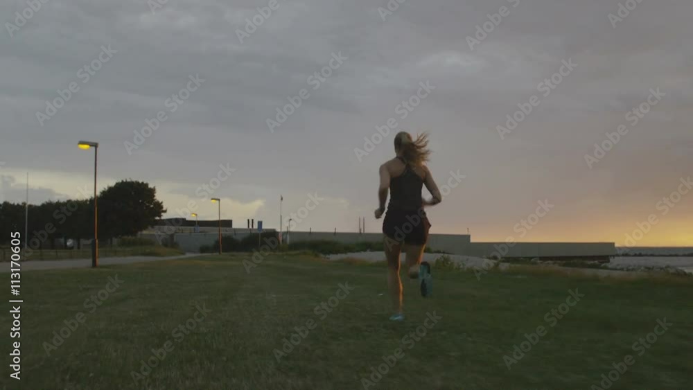 a young woman running at the ocean at sunset a young woman running at the ocean at sunset
