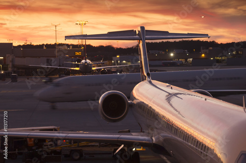 The setting sun illuminates the busy airport ramp at this commerical airline hub. photo