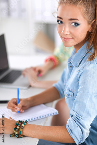 Two women working together at office  sitting on the desk