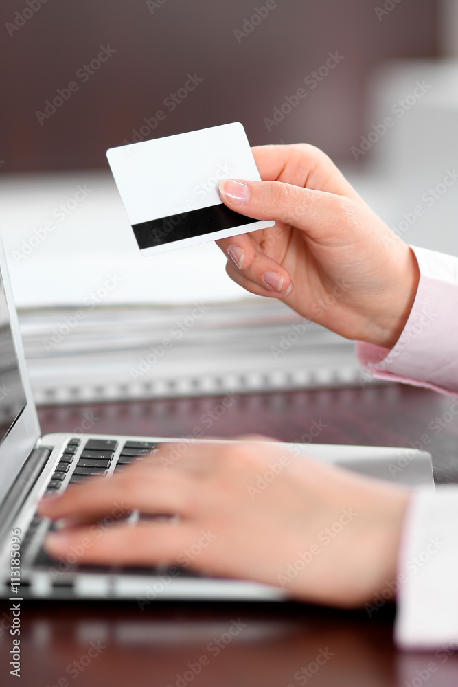 Close up of business woman hands using credit card and laptop computer Close up of business woman hands using credit card and laptop computer