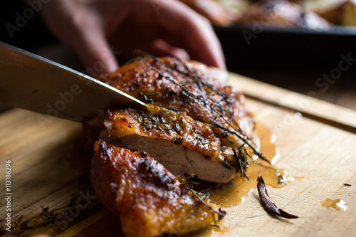 Person slicing roast turkey with knife photo