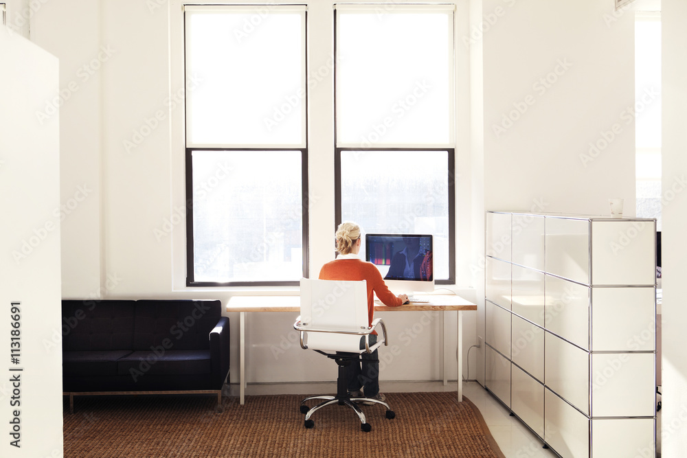 Woman sitting at desk facing window Stock Photo Adobe Stock