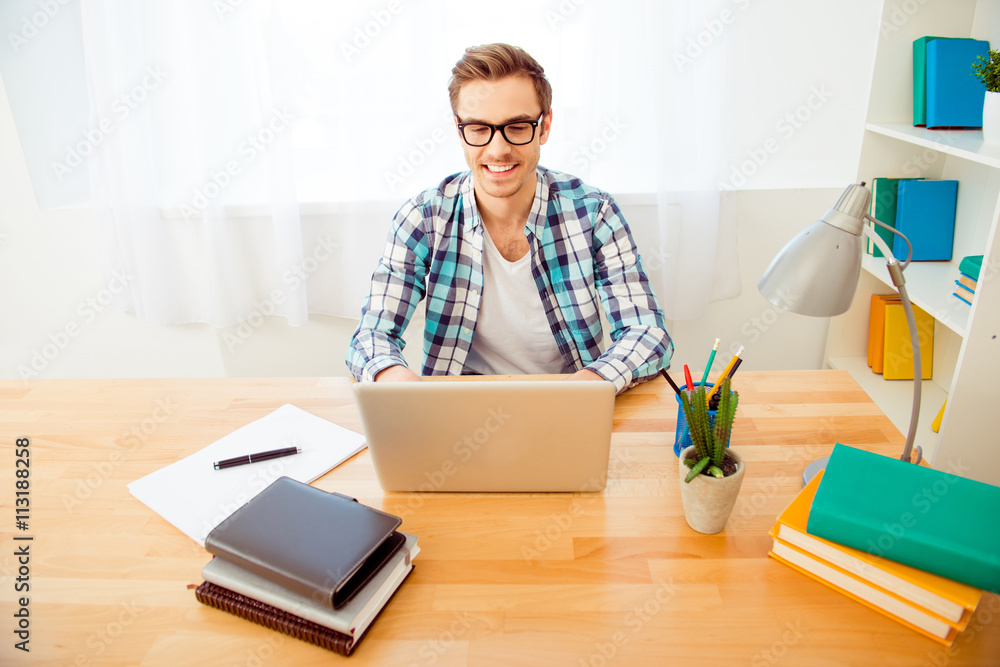 Cheerful guy in glasses writing his new book 