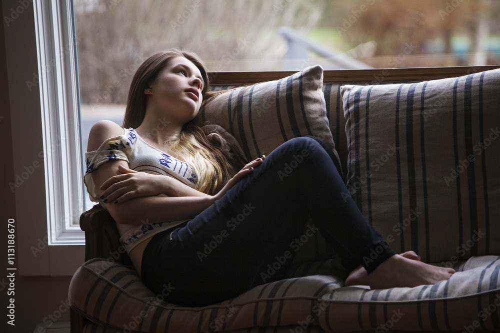 Teenage girl (14-15) relaxing on sofa Teenage girl (14-15) relaxing on sofa