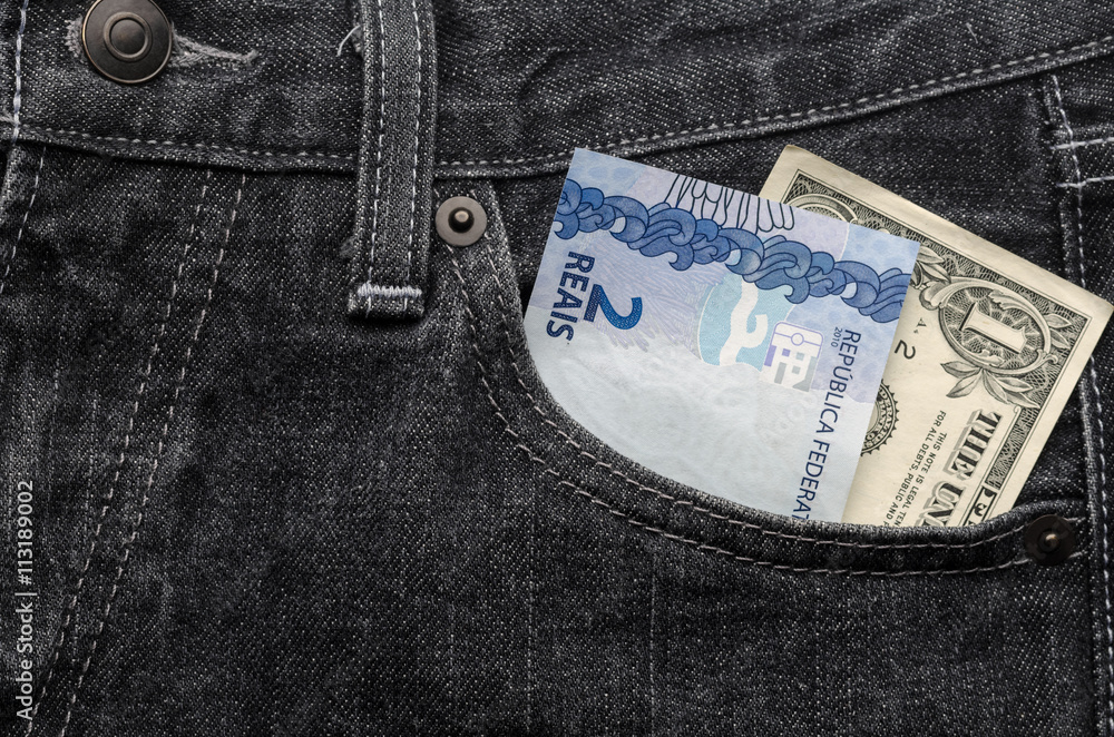 One dollar and two brazilian money inside jeans pocket Stock Photo | Adobe  Stock