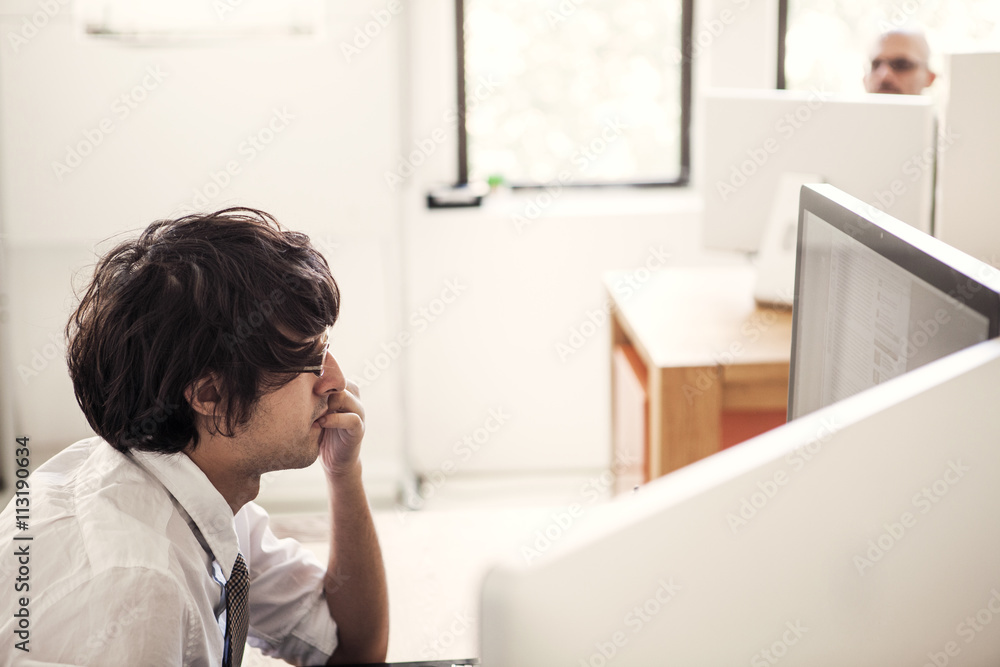 Side view of businessman working on computer in the office Side view of businessman working on computer in the office