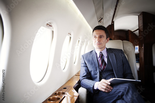 Man with tablet on airplane photo