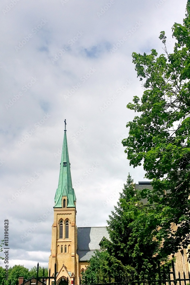 Old church steeple against cloudy sky