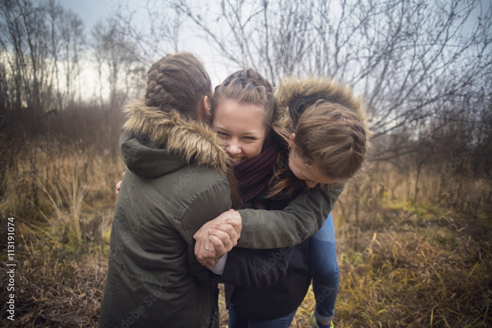 Young women playing and hugging in field Young women playing and hugging in field