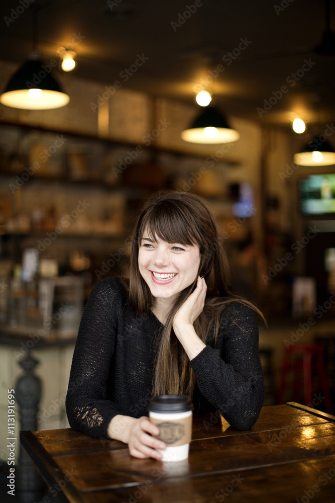 Young woman laughing in cafe Young woman laughing in cafe
