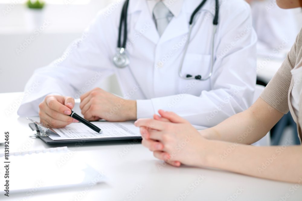 Doctor and patient are discussing something, just hands at the table Doctor and patient are discussing something, just hands at the table