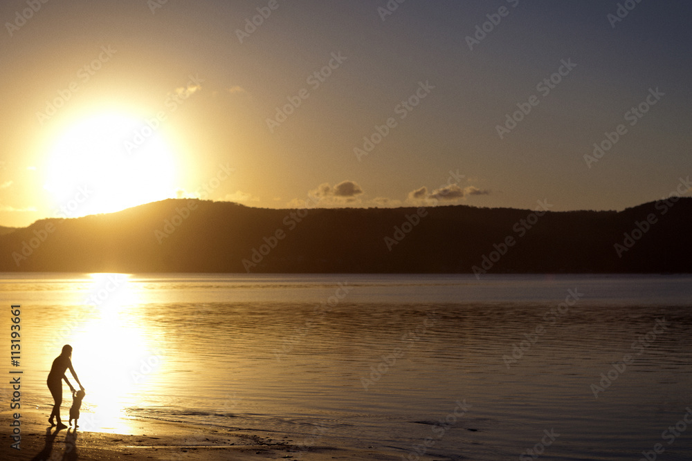 Silhouette of mother and son walking on beach Silhouette of mother and son walking on beach