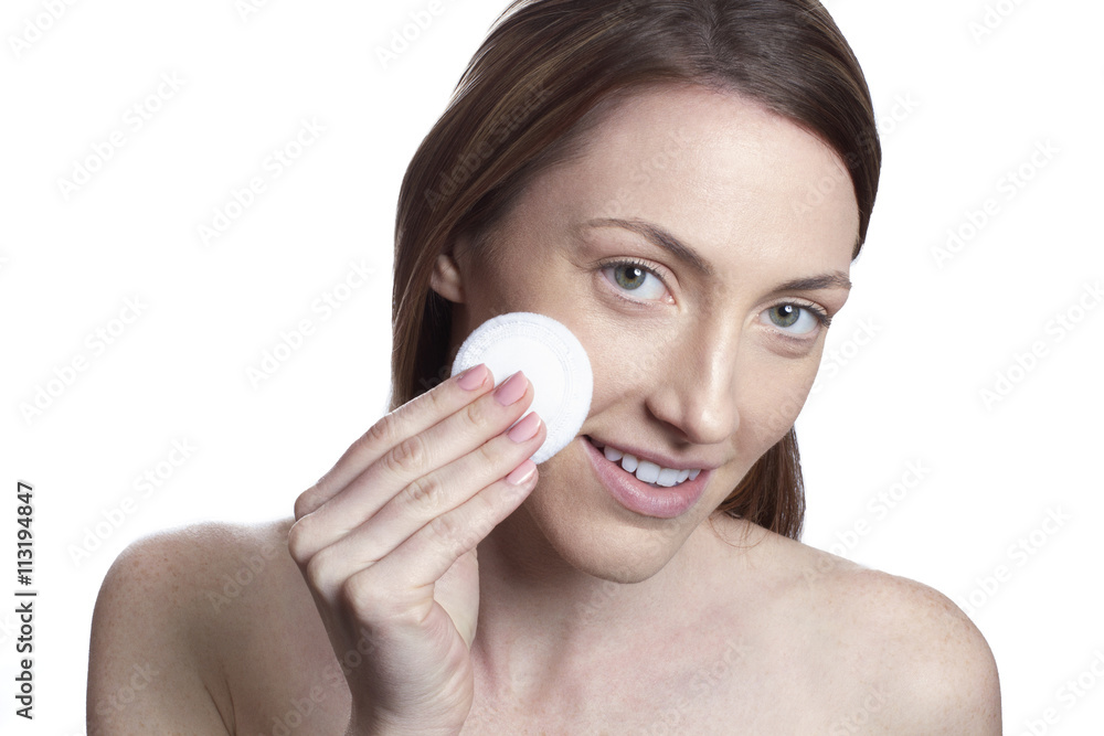 Woman cleaning face with cotton pad Woman cleaning face with cotton pad