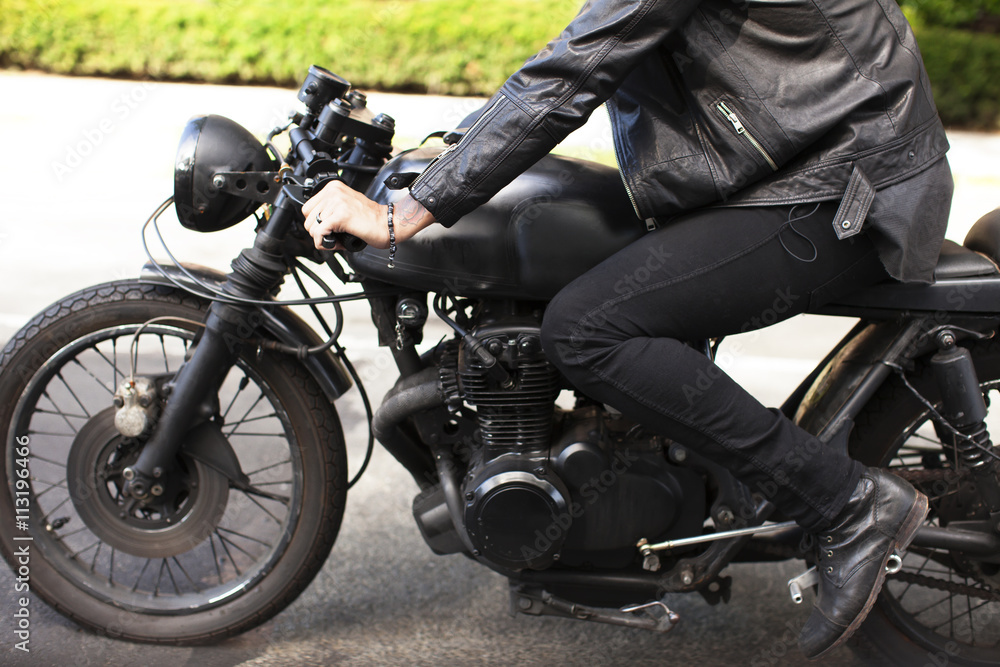 Cropped image of man sitting on motorcycle at road Cropped image of man sitting on motorcycle at road