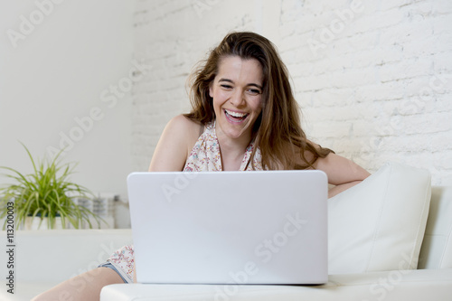 young beautiful woman working with laptop computer smiling happy or doing online internet shopping
