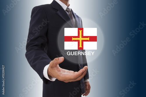 Businessman hand showing Guernsey Flag 