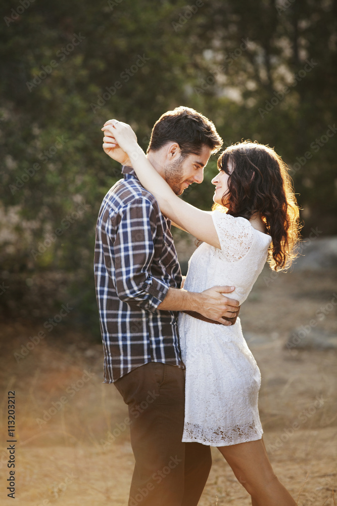 Side view of romantic couple standing on field during sunny day Side view of romantic couple standing on field during sunny day