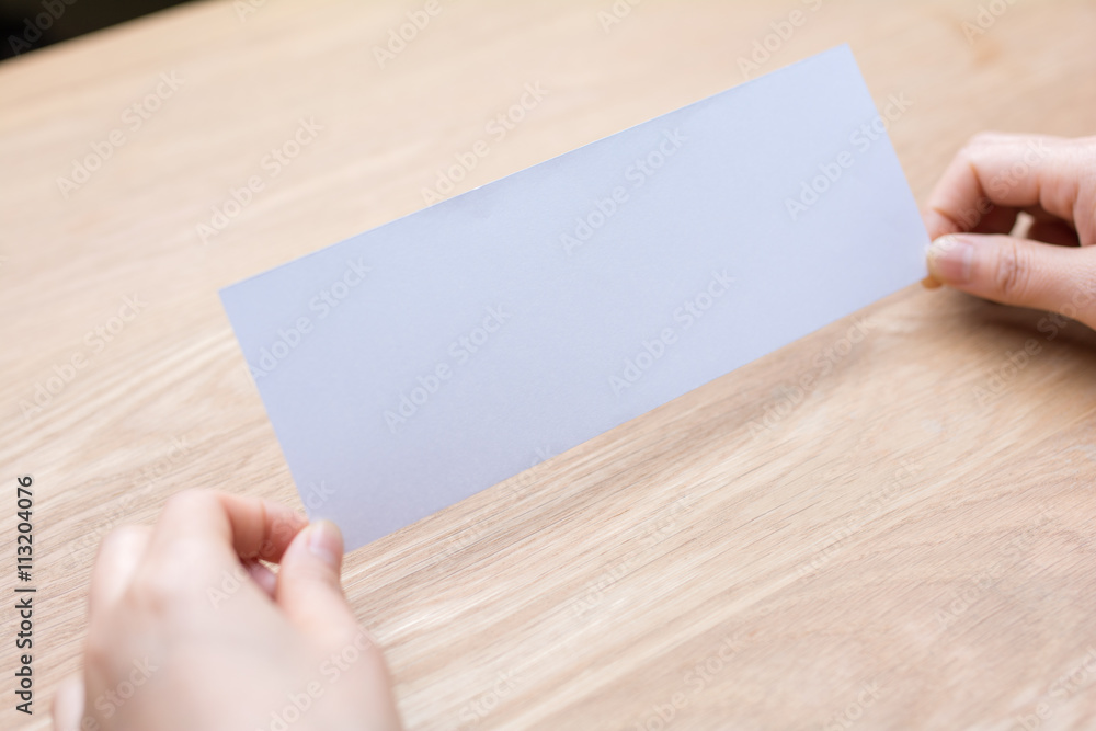 woman's hand holding white blank paper woman's hand holding white blank paper