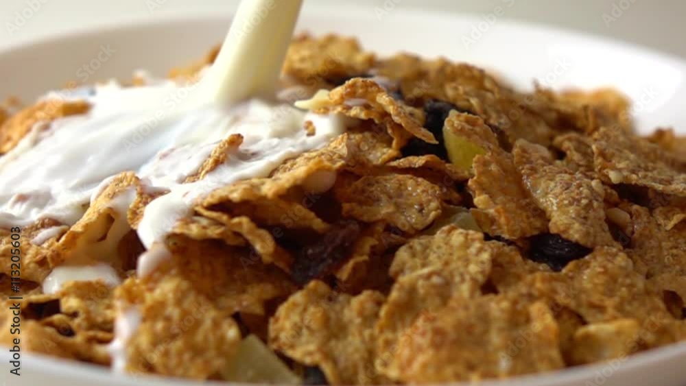 Super slow motion video of milk being added to corn flakes on white plate Super slow motion video of milk being added to corn flakes on white plate