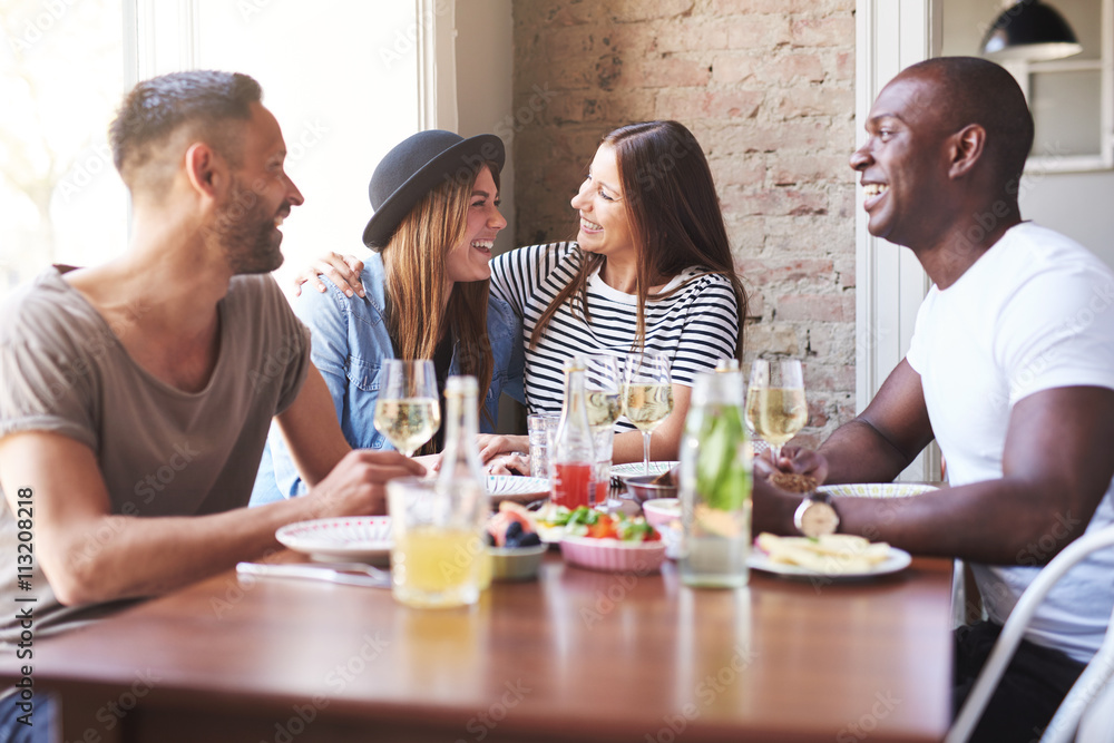 Woman hugging friend at dinner table Woman hugging friend at dinner table