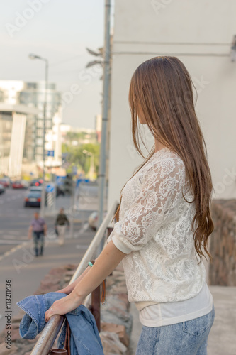 beautiful girl on a background of city streets at sunset
