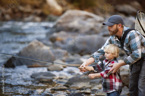 Father and son fishing in river